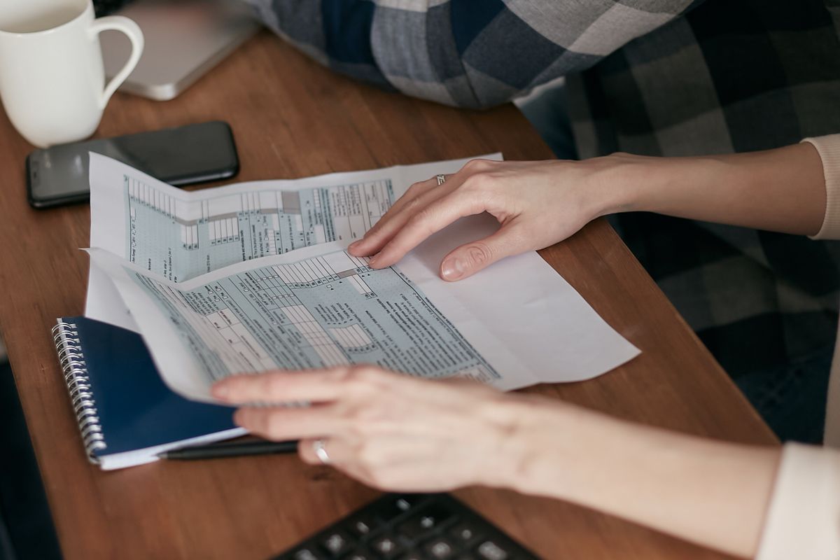 Hands reviewing tax forms at a desk